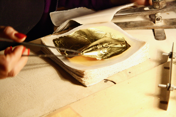 Taking the gold leaf out to trim it in a precise form